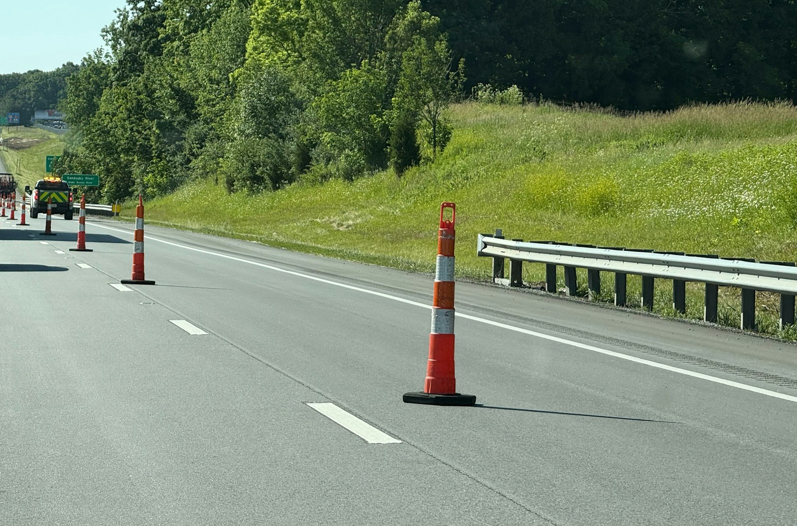 Traffic cones and a guardrail marking a controlled highway lane